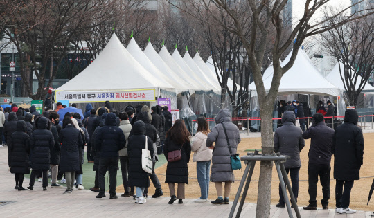 15일 오전 서울광장 선별진료소에서 시민들이 검사를 기다리고 있다. 이날 0시 기준 코로나19 신규 확진자는 5만7177명이다. 연합뉴스